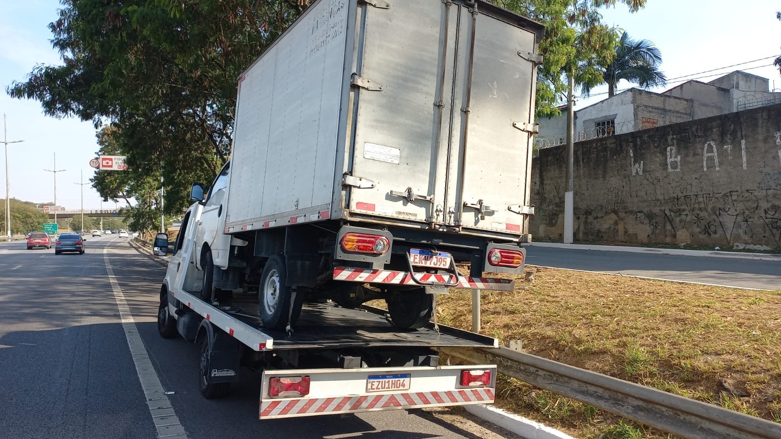 Caminhão baú sendo transportado em rodovia
